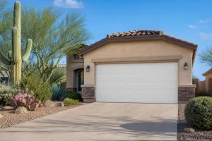 Modern residential garage door exterior on a stucco Phoenix Arizona home, illustrating a completed garage door opener installation